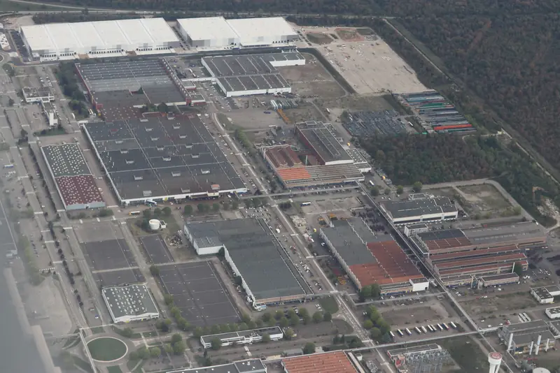 Vue aérienne de l'usine automobile de Sausheim, près de Mulhouse, halls, parkings et château d'eau, en septembre 2026.